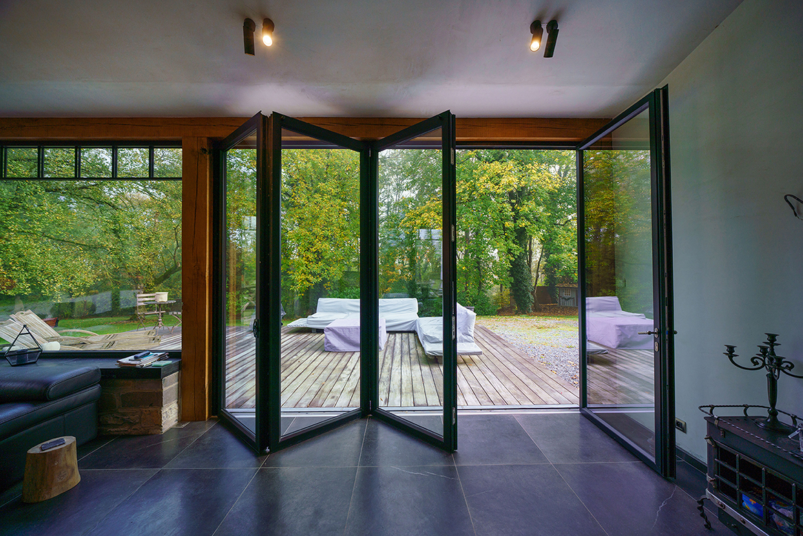 Baie vitrée accordéon en aluminium sur mesure offrant une ouverture totale vers une terrasse et un jardin